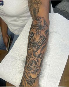 a woman's arm with flowers and butterflies on it