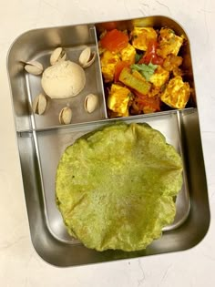 a metal tray filled with food on top of a table