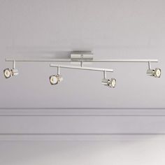 an overhead track light with four lights on each side and three spotlights in the middle