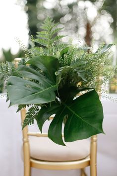 a chair with a plant in it on top of a white cloth covered tablecloth