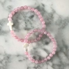 A dainty Mother of Pearl cross adorns these hand strung Pink Jade beaded bracelets. These look great paired with our Gold Ball Beaded Bracelet or our Name Bracelets! I love mixing textures together! This bracelet is made with high quality elastic. This bracelet stretches to fit most wrists and is approximately 6.5-7" in length + 6" for kiddos. Details:- Pink Jade Beading- Mother of Pearl Cross- Stretches to fit most wrists approximately 6.5-7" in length + 6" for kiddos. Your jewels will arrive i Pink Hand-wrapped Beaded Bracelets For Friendship, Adjustable Pink Spiritual Friendship Bracelets, Pink Adjustable Spiritual Friendship Bracelets, Dainty Pink Bracelets With Gemstone Beads, Dainty Pink Gemstone Bead Bracelets, Dainty Pink Gemstone Beads Bracelet, Adjustable Handmade Pink Rosary Bracelet, Dainty Hand-strung Stretch Bracelet For Gift, Dainty Pink Beaded Bracelets With Gemstone Beads