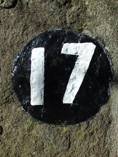 a black and white sign with the number seven painted on it's side in cement