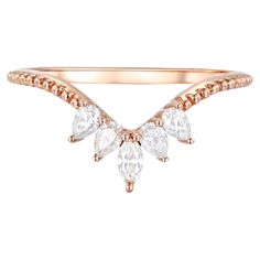 a rose gold ring with three pear shaped diamonds