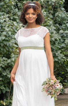 a woman in a white dress holding a bouquet