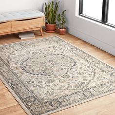 a large area rug in the corner of a room with wooden floors and potted plants