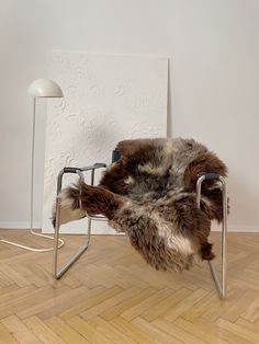 a chair that has some kind of fur on it in front of a white wall