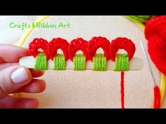 someone is stitching together red and green yarn