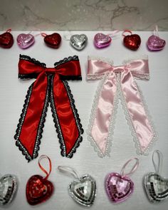 valentine's day decorations are laid out on a white table with red and pink ribbons