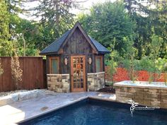 a small wooden building next to a pool with a hot tub in the middle of it