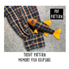 an image of a fish toy on the floor with text overlay that reads, trout pattern memory fish keepsake