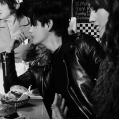 black and white photograph of two people sitting at a table with food in front of them