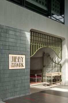 an entrance to a building with a bench in the middle and a sign that says, liberty by the park