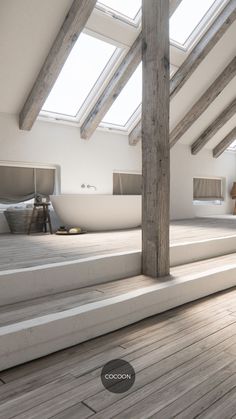 an empty room with wooden floors and skylights on the roof, is shown in this image