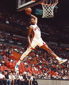 a basketball player dunking the ball in front of an audience