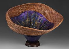 a purple and brown basket sitting on top of a wooden stand