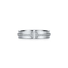 This narrow ring design features scintillating round brilliant diamonds and an iconic "T" motif. As multifaceted as it is iconic, the Tiffany T collection is a tangible reminder of the connections we feel but can't always see. For maximum impact, wear this style stacked with other Tiffany T rings. 18k white gold with round brilliant diamonds; 4.5 mm wide; Carat total weight .13 | Tiffany T Narrow Diamond Ring in 18K White Gold, 4.5 mm Wide, Size: 7 Tiffany Wedding Band, Plain Gold Bangles, My Wedding Ring, Minimal Bracelet, Mens Diamond Wedding Bands, Tiffany T, Dad Jewelry, Gay Wedding, Gold Cuffs