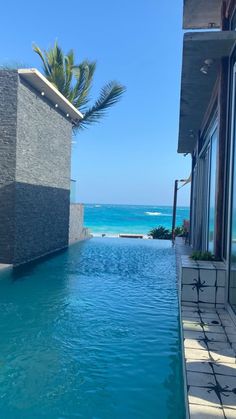 an empty swimming pool with the ocean in the background