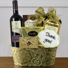 a bottle of wine and some cookies in a basket with a thank you sign on it