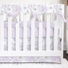 a white crib with pink and purple flowers on it