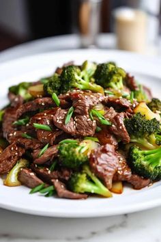 a white plate topped with beef and broccoli