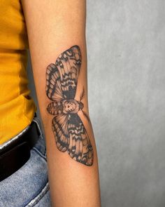 a small butterfly tattoo on the arm