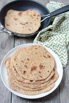 tortillas on a plate with a skillet in the background