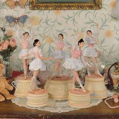 a group of ballerinas standing on top of pedestals in front of a painting