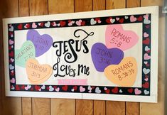 a bulletin board with hearts and the words jesus loves me