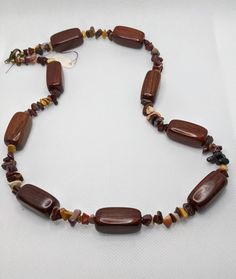 Large rectangular polished wooden beads alternating with multi colored gemstone chips in beautiful fall colors.  Finished with a bronze lobster clasp. Brown Beaded Necklace, Wooden Bead Necklaces, Beaded Chain, Wooden Beads, Chain Styles, Gemstone Colors, Selling On Etsy, Sell On Etsy, Necklace Etsy