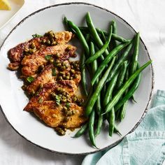 a white plate topped with green beans and chicken