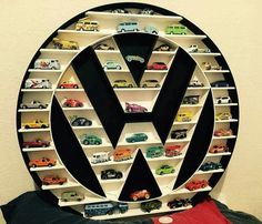 a vw logo made out of shelves filled with toy cars on top of each other