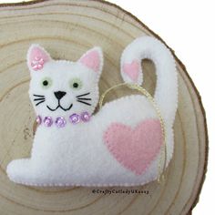 a white cat ornament with pink hearts on it