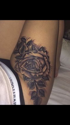 a woman's thigh with a rose tattoo on it