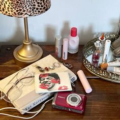 an assortment of makeup, eyeglasses and other items on a table