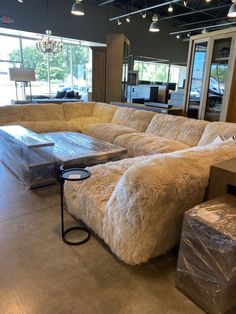 a large sectional couch in a showroom with boxes on the floor and other furniture