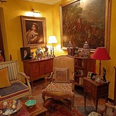 a living room filled with furniture and paintings