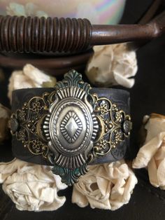 "Country leather bracelet cuff, western jewelry Distressed black embossed genuine leather 1 1/2\" strap has been adorned with an oval southwestern silver concho which sets on a detailed antiqued bronze filigree which has been given a rich patina attached to the leather with two textured gunmetal rivets. One gunmetal snap has been placed to fit up to a 7\" wrist. I can add another snap for a smaller or larger wrist size but you need to convo me before purchasing The last photos feature other item Bohemian Festival Bracelet With Patina, Bohemian Hand Tooled Jewelry For Rodeo, Bohemian One-of-a-kind Cuff Bracelet, Adjustable Western Leather Bracelet For Festivals, Bohemian Concho Jewelry For Rodeo, Bohemian Hand-tooled Cuff Bracelet, Bohemian Stamped Cuff Bracelet Gift, Bohemian Stamped Cuff Bracelet For Gift, Vintage Handmade Cuff Bracelet For Festivals