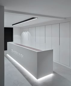 a white counter sitting in the middle of a room with lights on top of it