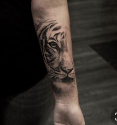 a hand with a tiger tattoo on it's left arm and the wrist is shown