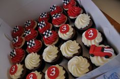 cupcakes with red and white frosting are in a box on the table