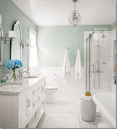 a white bathroom with two sinks and a bathtub