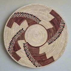 a brown and white basket sitting on top of a table next to a gray wall