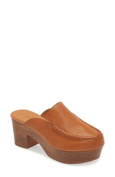 A moc toe and loafer-inspired topline add sophisticated elements to a leather mule lofted by a chunky platform and block heel. 3" heel; 1 1/4" platform Cushioned footbed Leather upper and lining/rubber sole Imported Brown Loafers With Sculpted Heel And Round Toe, Classic Workwear Clogs For Fall, Classic Mules With Wooden Heel For Work, Brown Leather Loafers With Sculpted Heel, Fall Workwear Mules With Wooden Heel, Brown Stacked Heel Heels For Work, Brown Mules With Wooden Heel For Work, Brown Wooden Heel Mules For Work, Classic High Heel Leather Clogs