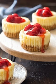 mini cheesecakes with strawberry topping on a wooden platter, ready to be eaten