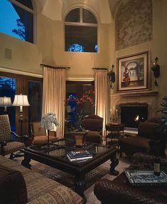 a living room filled with furniture and a fire place in the middle of a room