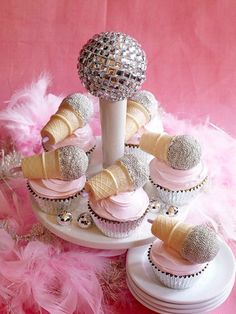 cupcakes with pink frosting and ice cream cones on a cake platter