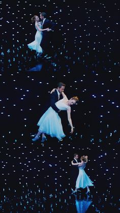 two people in white dresses are dancing on stage with blue and black lights behind them