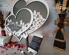 two heart shaped cutouts on display next to flowers and other items in front of a wall