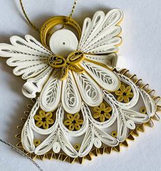 an ornament made out of white paper with gold accents