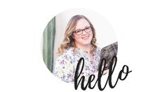 a woman with glasses is smiling and holding a book in front of the words hello